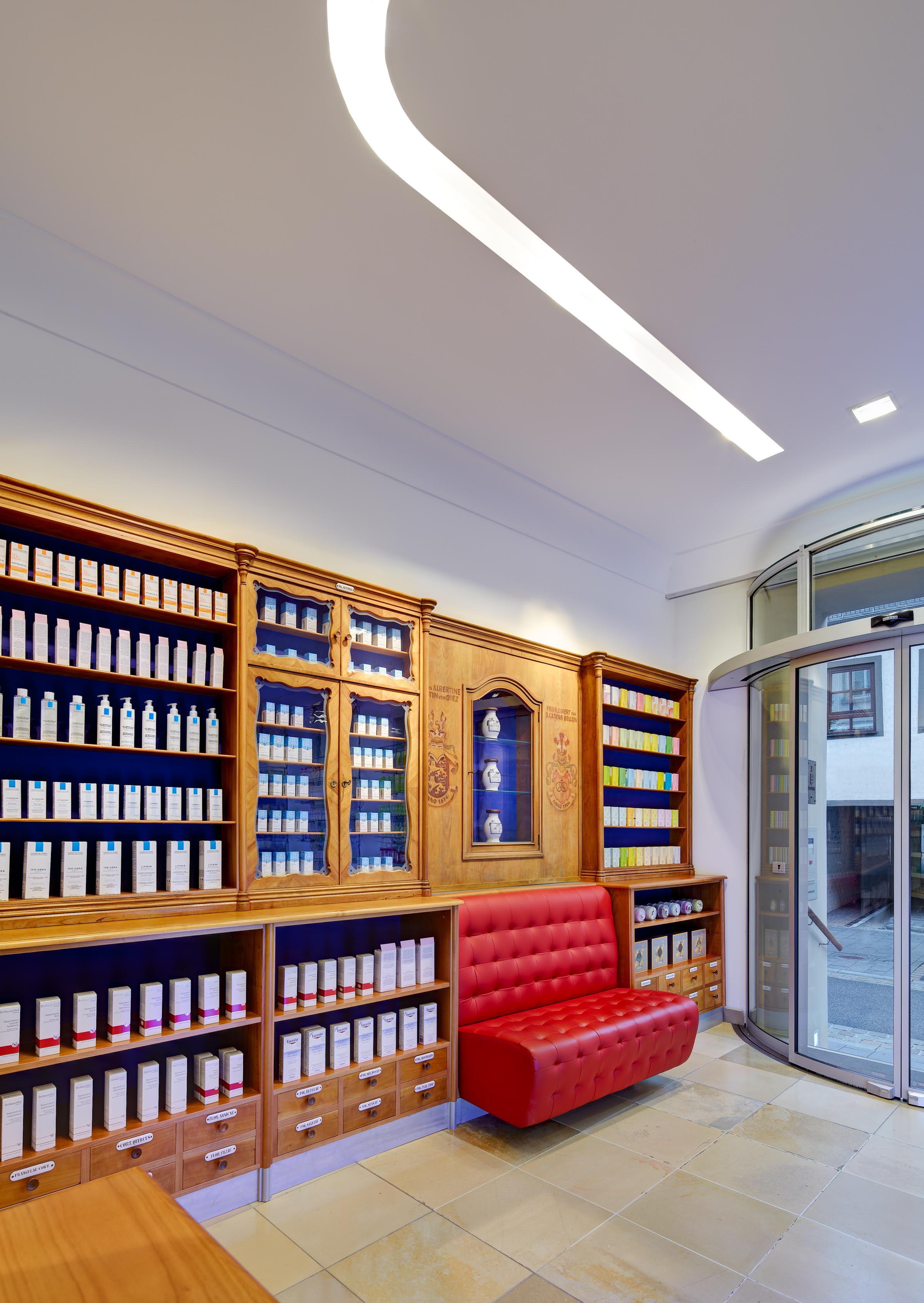 View from the entrance into the historic dispensary with waiting bench and restored pharmacy interior