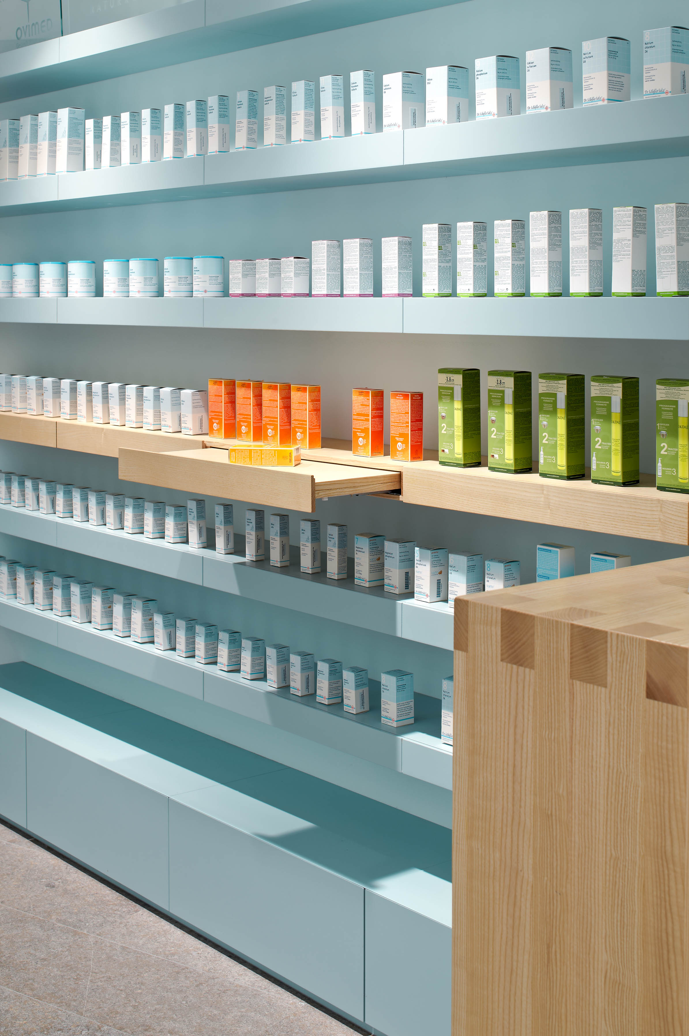 Self-service shelving with pull-out display tray and ash wood details