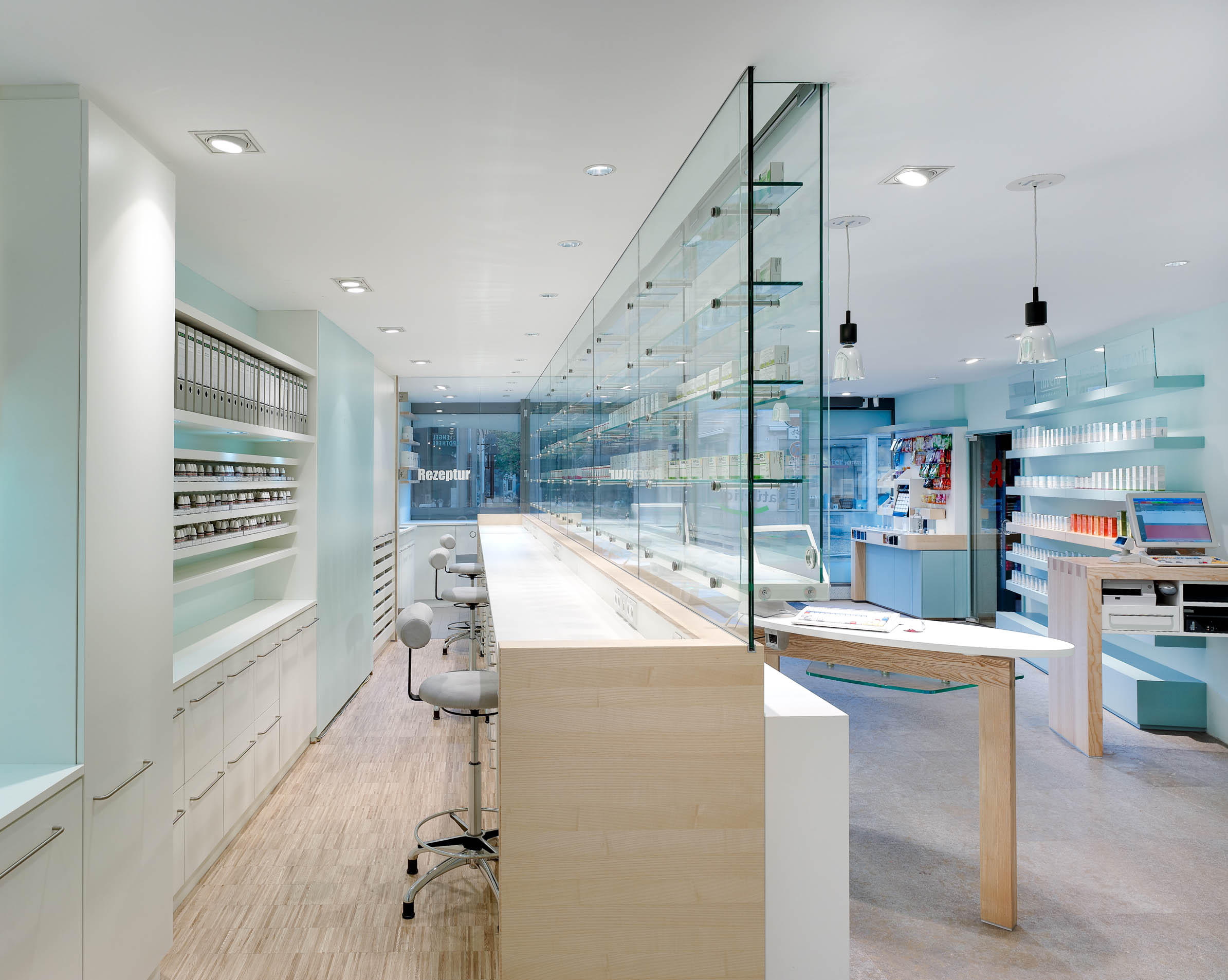 Workstations behind the glazed medicine display with a view into the dispensary