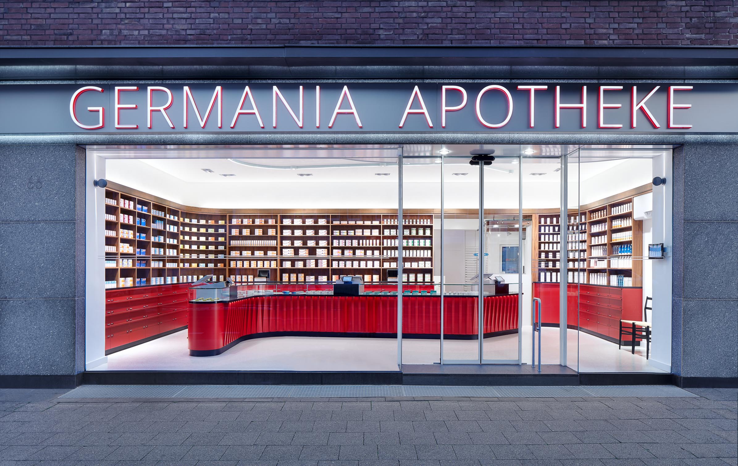 Façade of Germania Pharmacy in Aachen with illuminated signage and shop windows