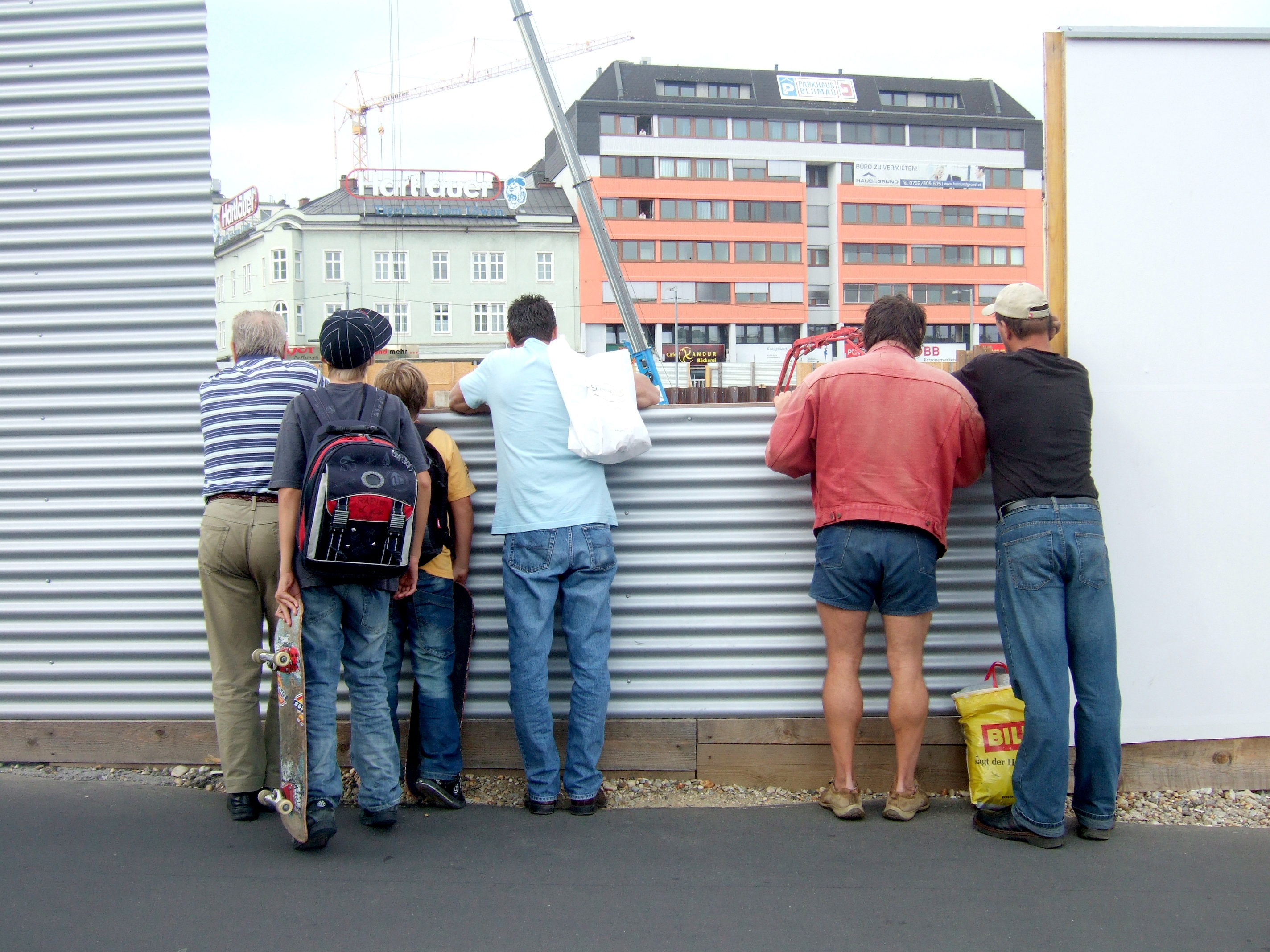 People looking over a construction fence